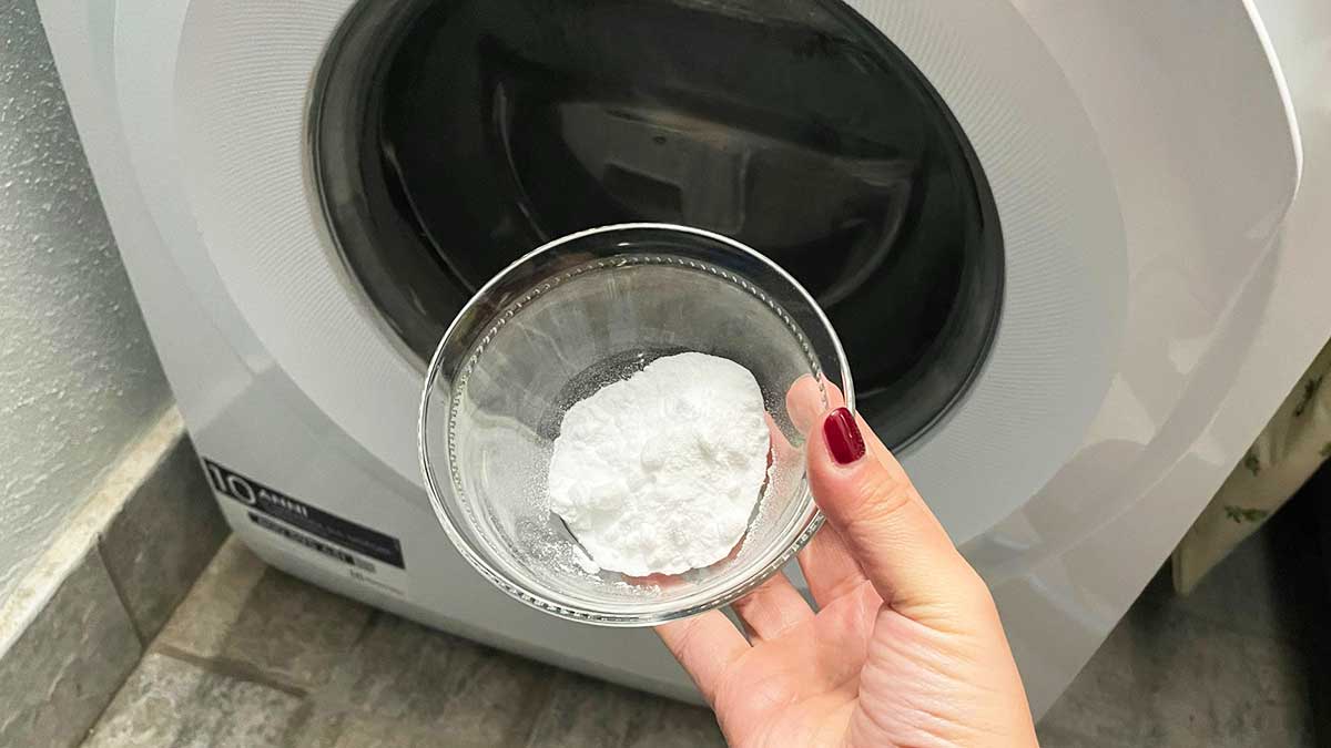 Bicarbonato di sodio bianco pronto da essere inserito in una lavatrice aperta pronta per il lavaggio